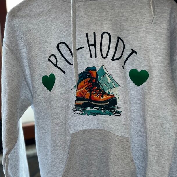 Siva kapuca s toplotnim transferjem napisa 'PO-HODI', ilustracijo pohodniškega čevlja in srčki